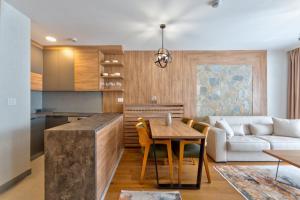 a kitchen and living room with a table and a couch at Mountain Pearl Zlatibor in Zlatibor