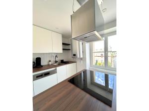 a kitchen with white cabinets and a large window at Les Hauteurs de La Libération- Poitiers in Poitiers +4 photos