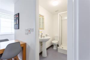 a white bathroom with a sink and a toilet at North Devon Getaways in Ilfracombe