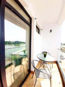 une porte en verre menant à un balcon avec une table et des chaises dans l'établissement Tasos - Rooms with see View, à Eforie Nord