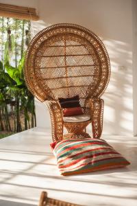 a wicker chair with a pillow on a floor at Villa Aditi - Amazing Beachfront Villa in Amphoe Koh Samui