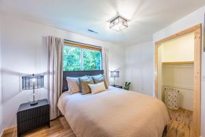 a bedroom with a large bed and a window at Fern House Rustic Modern Hiking Base Sequim in Sequim