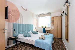 a bedroom with a bed with two teddy bears on it at Sapphire Hotel Rooms Lechicka in Poznań