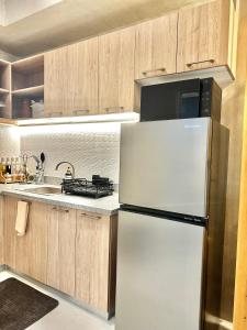 a kitchen with a refrigerator and a sink at WV Tower 2 Condo Sage Unit in Iloilo City