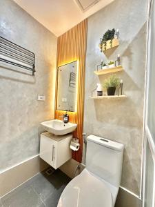 a bathroom with a white toilet and a sink at WV Tower 2 Condo Sage Unit in Iloilo City