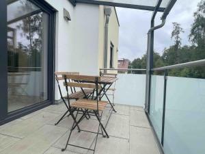 a balcony with a wooden table and chairs on it at MAX115 zentrale Monteurwohnung in Maxhütte-Haidhof