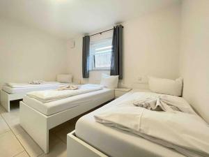 a room with two beds and a window at MAX115 zentrale Monteurwohnung in Maxhütte-Haidhof