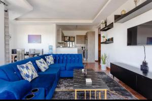 a large blue couch in a living room at Skyline Aramis Apartment Westlands,2bedroom,2baths in Nairobi