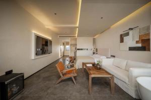 a living room with a white couch and a table at 不晚里予日照金山丨雪山全景度假酒店白沙古镇店 in Baisha
