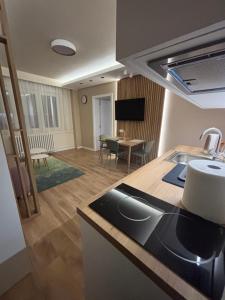 eine Küche und ein Wohnzimmer mit einem Tisch in der Unterkunft Hello One 2 Apartman in Šabac + 7 Fotos