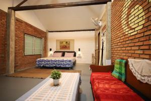 a bedroom with a bed and a couch in a room at Aum Hum Homestay in Fang