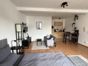 a bedroom with a bed and a living room with a kitchen at Urban Holiday Apartment in Osnabrück 11006 in Osnabrück +10 photos