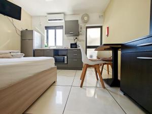 a bedroom with a bed and a desk and a kitchen at Corner view 4 in Marsaskala