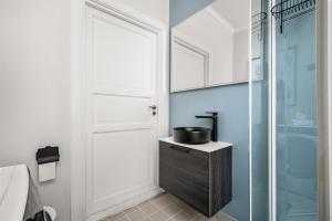 ein Badezimmer mit Waschbecken und Glasdusche in der Unterkunft Bergen Beds Apartments - A Front Row Experience in Bergen + 15 Fotos