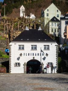ein weißes Gebäude mit einem schwarzen Dach und einem Tunnel in der Unterkunft Bergen Beds Apartments - A Front Row Experience in Bergen