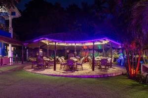a group of tables and chairs under a tent at night at 3 BHK Apartment with swimming pool in Jāmb