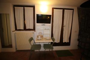 a small table and chairs in a room with a television at La Casetta Sulle Mura in Santarcangelo di Romagna +6 photos