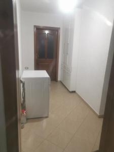 a hallway with a white refrigerator and a door at Kukesi Center Apartments in Kukës