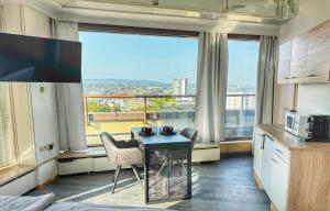 a kitchen with a table and chairs and a large window at Zentrale Penthouse Suiten mit Goldstadtblick in Pforzheim