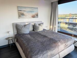 a bedroom with a large bed with a large window at Zentrale Penthouse Suiten mit Goldstadtblick in Pforzheim