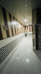 a hallway with a tile floor and wooden walls at Shine Guest House in New Delhi