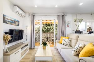 Una sala de estar con un sofá blanco y un televisor. en Nordik Apartments Village - Rincón "Brevik", en Rincón de la Victoria