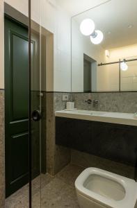 a bathroom with a toilet and a sink and a mirror at Private Premium Apartment in Plovdiv in Plovdiv