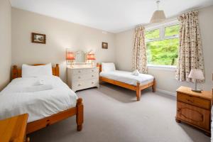 a bedroom with two beds and a window at Charming 2-Bed Cottage on Tranquil Raera Farm in Kilninver +11 photos