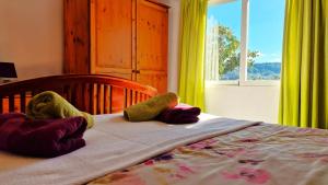 a bed with two stuffed animals on it with a window at Finca Craig, Spacious Farmhouse with amazing garden and private heated pool in Rótova