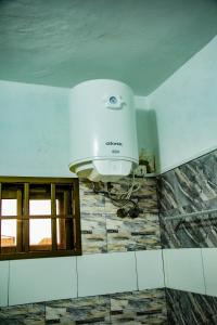a bathroom with a hair dryer on the wall at Villa Saint Michel in Lomé +4 photos