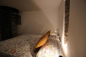 a bed with a yellow pillow sitting on top of it at La Casetta Sulle Mura in Santarcangelo di Romagna