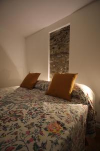 a bedroom with a bed with two pillows on it at La Casetta Sulle Mura in Santarcangelo di Romagna