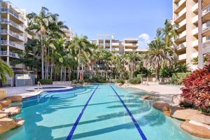 una piscina con palmeras y edificios en Inner-City 1-Bed with Pool & Spa, en Brisbane
