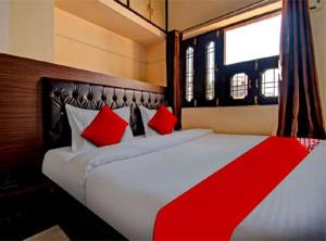 JāmbにあるHotel Royal Palaceのベッドルーム1室(大型ベッド1台、赤い枕付)