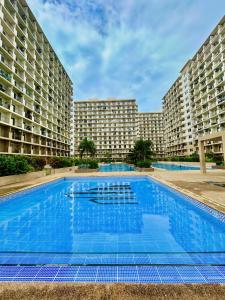 a large swimming pool with two large buildings at Studio Retreat with Balcony and Pool in Suba