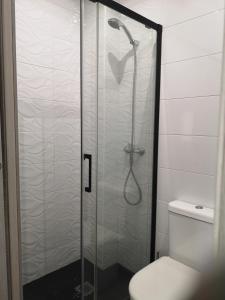 a shower with a glass door next to a toilet at El rincon de la playita VFT/CA /03874 in Cádiz +7 photos