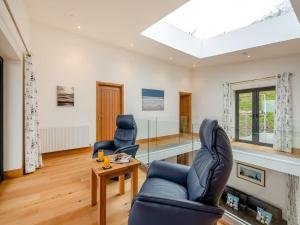 a living room with two chairs and a table at Bodwennol - a stunning house! in Aberdyfi +32 photos