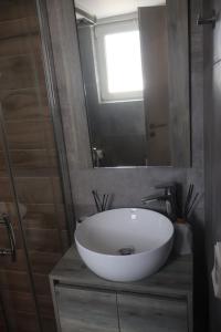 a bathroom with a white sink and a mirror at Athenean Coastal Getaway in Athens +6 photos