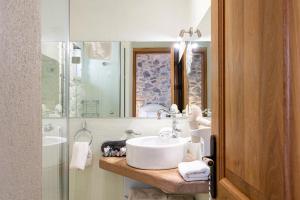 a bathroom with a sink and a mirror at Argyriou Wine Tasting Guest House in Polydrossos
