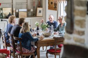 a group of people sitting around a dining room table at La Rose du Petit Bois in Saint-Didier-au-Mont-dʼOr