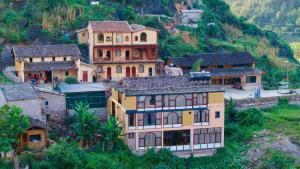 a group of houses on a hill with trees at Khói ở Lô Lô Chải in Dồng Văn