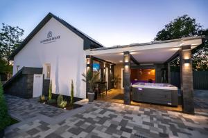 una casa con una vasca da bagno in un cortile di Gyopárosi Deluxe Private Wellness House 4 Csillag a Orosháza