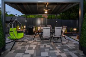patio con tavolo e sedie sotto un baldacchino di Gyopárosi Deluxe Private Wellness House 4 Csillag a Orosháza
