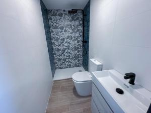 a white bathroom with a toilet and a shower at Boliches 71 Hostel in Fuengirola