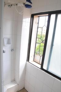 a bathroom with a shower and a window at Shaba Home in Nairobi