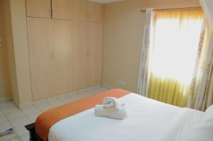a bedroom with a bed with a towel on it at Shaba Home in Nairobi +1 photo