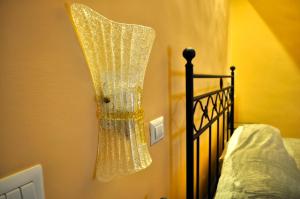 a chandelier hanging on a wall next to a bed at villa verde sul mare in Vietri sul Mare