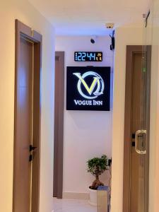 a sign on a wall in a room with a plant at Vogue Inn Abu Dhabi in Abu Dhabi +14 photos