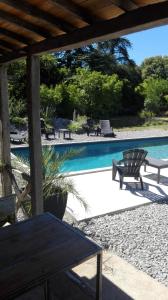a swimming pool with a table and benches next to it at Le Clos de La Chardonnière in Saulce-sur-Rhône