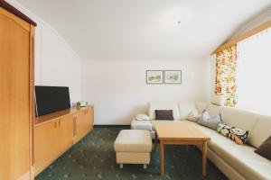 a living room with a couch and a tv at Das Jennerwein Appartement in Saalbach Hinterglemm